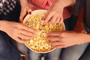 Close,up,,top,view,photo,of,women's,hands,taking,popcorn