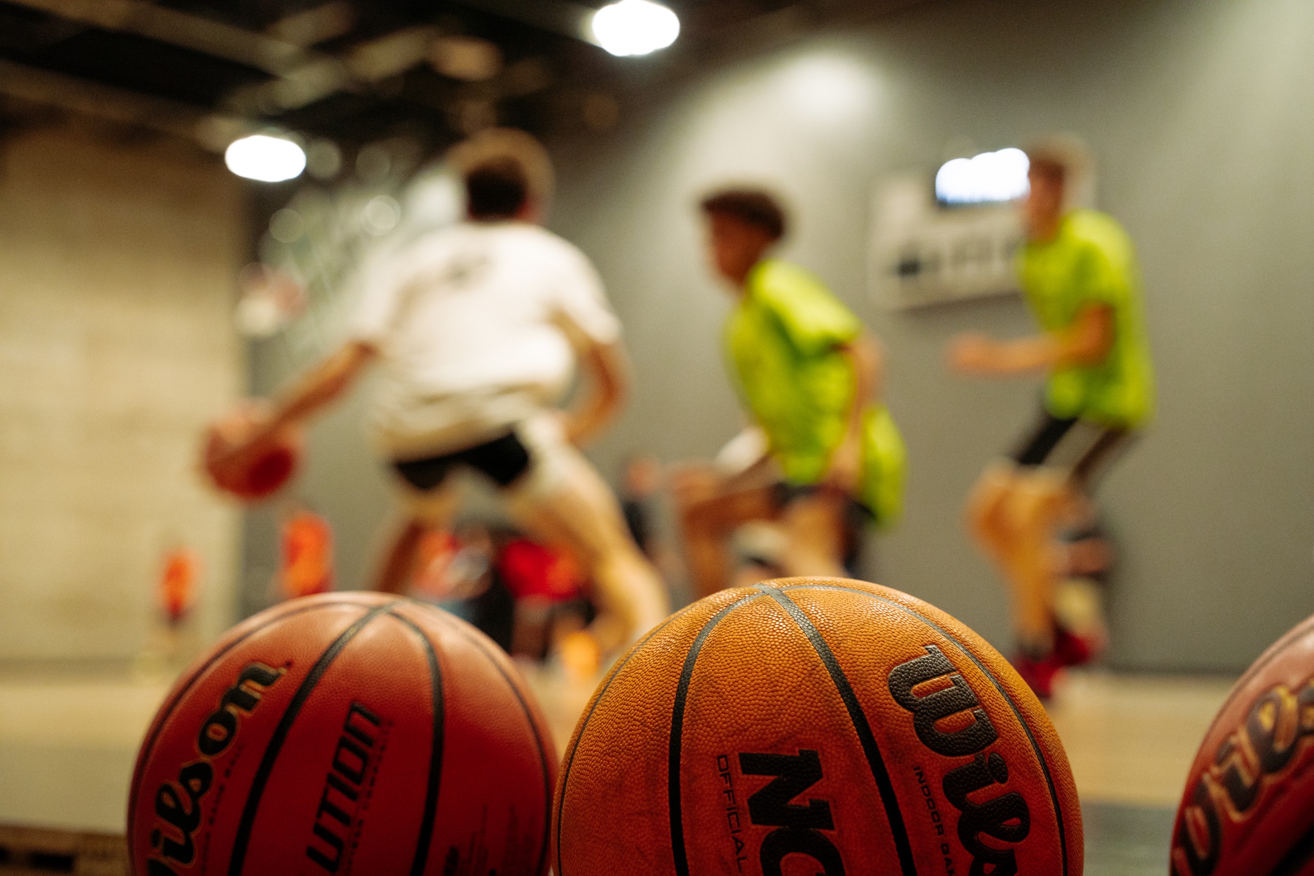 Kleine Jongen Die Een Basketbal Op Een Hof Stuiteren Stock Afbeelding