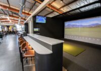 Hangar Club Denver interior photo of virtual golf facility and accompanying bar.