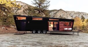 black Land Ark RV parked in front of a mountain range.