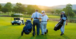 Group of Asian people businessman and senior CEO enjoy outdoor sport golfing together at country club. Healthy men golfer holding golf bag walking on fairway with talking together at summer sunset